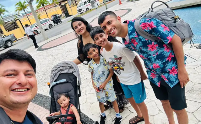 Our driver with a family of five and a baby in a stroller beside the van