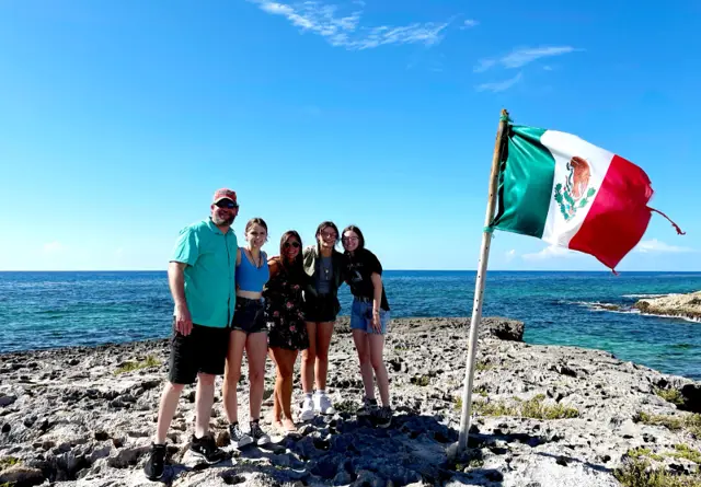 A family on the windward coast of Cozumel, the van behind them